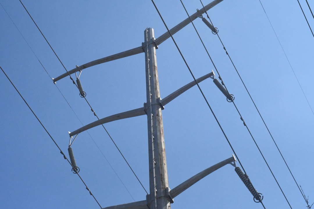 black electric post under blue sky during daytime